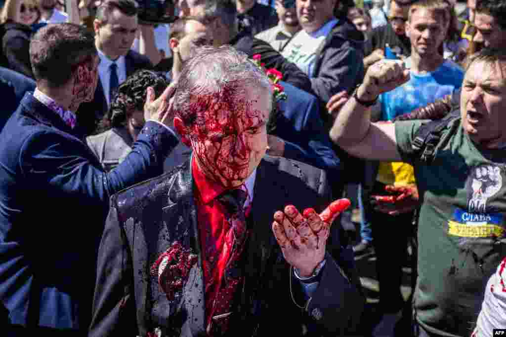 Russian Ambassador to Poland Sergey Andreev reacts after being covered with red paint during a protest prior a ceremony at the Soviet soldier war mausoleum in Warsaw, Poland, on the day of the 77th anniversary of the 1945 Soviet victory against Nazi Germany. 