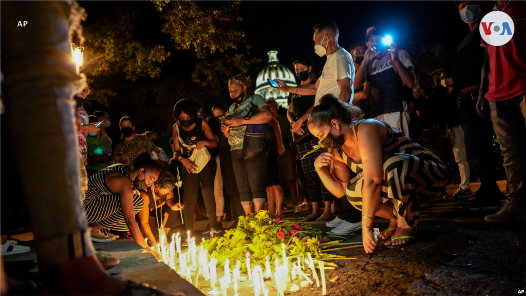 Velas iluminan los carteles con los rostros de algunas de las víctimas de la explosión en el hotel Saratoga. Asistentes a la vigilia prenden velas para conmemorar a las víctimas de la explosión causada, aparentemente, por una fuga de gas.