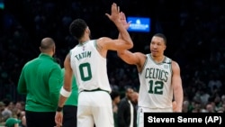 Jayson Tatum (0) et Grant Williams (12) des Boston Celtics célèbrent pendant la deuxième mi-temps du septième match de la demi-finale Est contre les Milwaukee Bucks, dimanche 15 mai 2022.