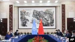 In this photo released by Xinhua News Agency, Chinese Foreign Minister Wang Yi, second right, meets with the United Nations High Commissioner for Human Rights Michelle Bachelet, left, in Guangzhou, in southern China's Guangdong province, May 23, 2022.