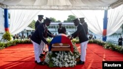 Los guardias de honor presidenciales colocan una bandera nacional sobre el ataúd del difunto presidente haitiano Jovenel Moise, quien fue asesinado a tiros, durante el funeral en la casa de su familia en Cabo Haitiano, Haití, el 23 de julio de 2021.
