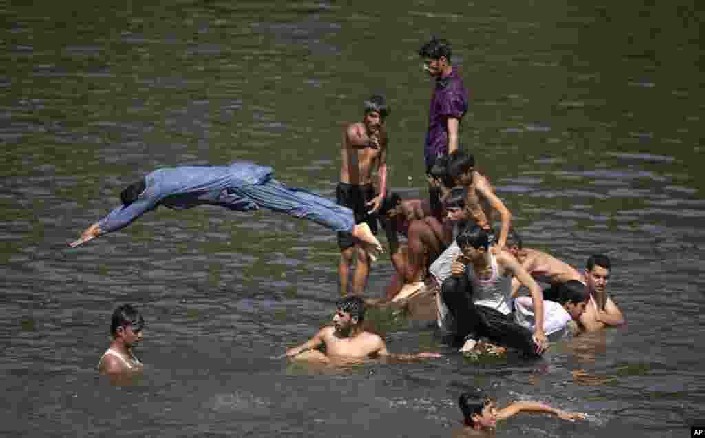 Warga mendinginkan diri di sungai saat suhu udara mencapai 38° C pada hari bulan Ramadan di Islamabad, Pakistan. 