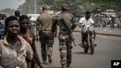 Instruktur militer tentara Prancis berjalan di salah satu jalan utama di Tanguietan, Benin utara, 28 Maret 2022. (Foto: AP)