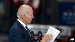Presiden AS Joe Biden tampak melihat pada lembar dokumen yang ia bawa ketika berbicara dalam kunjungannya ke pabrik Volvo di Hagerstown, Maryland, pada 7 Oktober 2022. (Foto: AP/Julio Cortez)