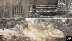 A Cambodian army soldier sits at damaged Cambodia's 11th century Hindu Preah Vihear temple.