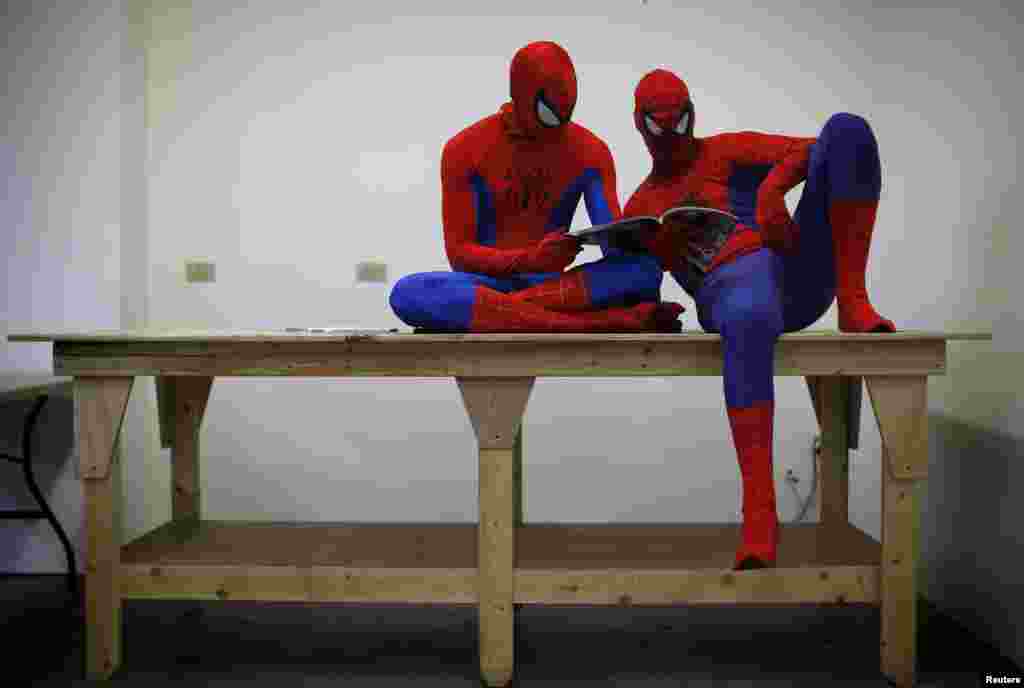 Peter Norbot and Kris Hamilton (L), dressed up as fictional comic book superhero Spider-Man, look through a magazine as they wait for their turn to audition to be a part of a promotional campaign for the upcoming release of the new movie "The Amazing Spider-Man 2" in Chicago, USA, Mar. 19, 2014.