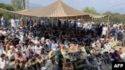 عسکریت پسندوں کے بچوں کے اسکول کی گاڑی پر حملے کے خلاف شرکا ڈرائیور کی لاش کے ہمراہ احتجاج کر رہے ہیں۔