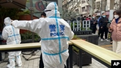 2022年4月1日上海靜安區的警察指揮居民排隊等待核酸檢測。