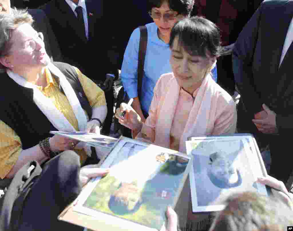 Burma's pro-democracy leader signs autographs outside the Swiss Parliament in Bern, Switzerland, June 14, 2012.