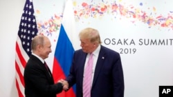 FILE - U.S. President Donald Trump and Russian President Vladimir Putin greet each other on the sidelines of the G-20 summit in Osaka, Japan, June 28, 2019.