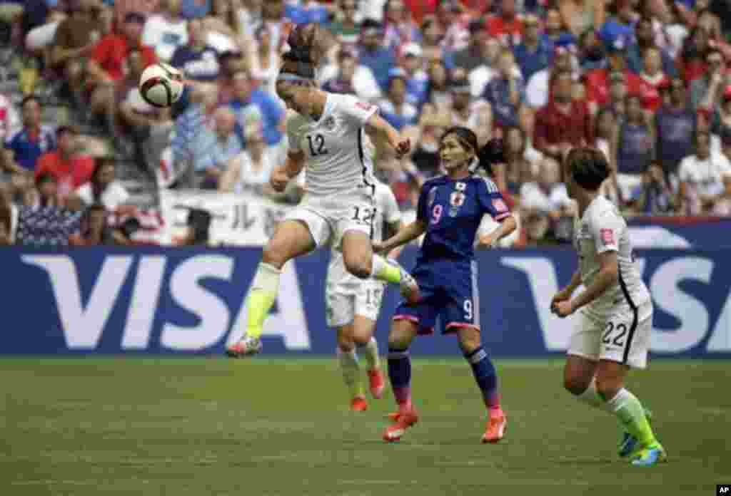 United States' Lauren Holiday (12) heads the ball above Japan's Nahomi Kawasumi (9) during the first half of the FIFA Women's World Cup soccer championship in Vancouver, British Columbia, July 5, 2015.