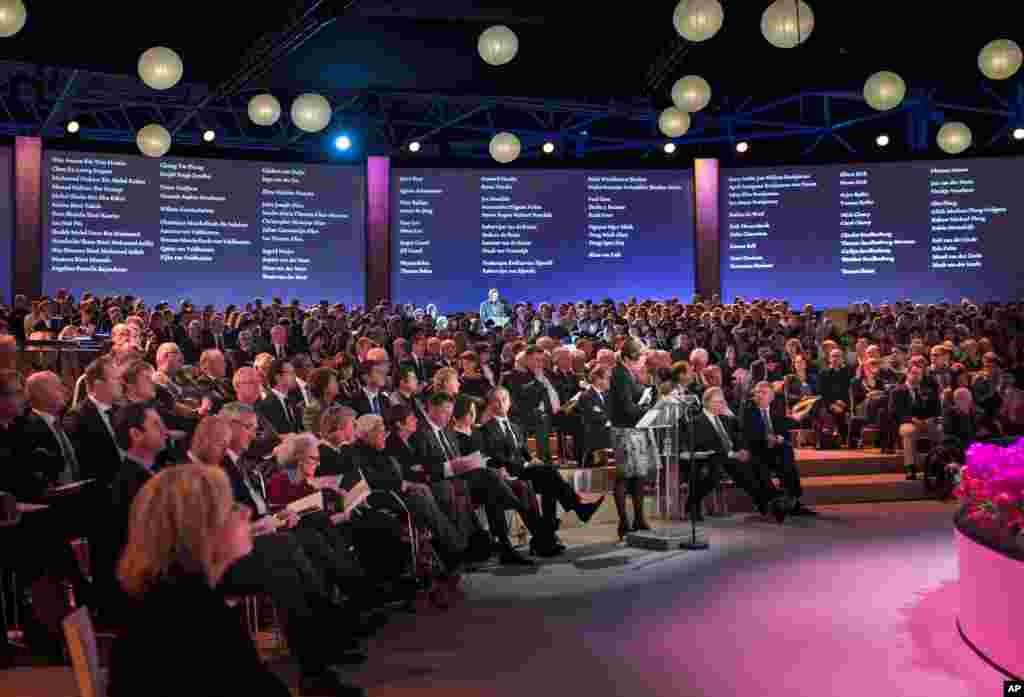 A relative reads out names of victims while images of the deceased are projected on a screen during a commemoration ceremony for relatives and friends of the victims of the Malaysia Airlines Flight 17 disaster at RAI in Amsterdam, Netherlands, Nov. 10, 2014.