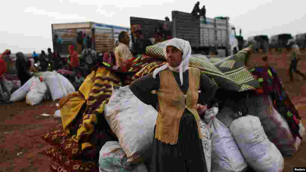 Comme des milliers d’autres réfugiés qui traversent la frontière syrienne pour la Turquie, cette femme attend un moyen de transport dans la ville de Kobani. (le 2 octobre) 