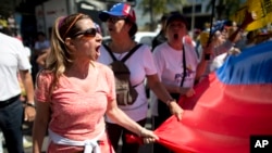 Una manifestante en Venezuela, grita "elecciones ahora", durante una protesta en Caracas el lunes 23 de enero de 2017. 
