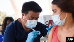 A CSULB student receives a first dose of the Pfizer Covid-19 vaccine during a City of Long Beach Public Health Covid-19 mobile vaccination clinic at the California State University Long Beach (CSULB) campus on August 11, 2021 in Long Beach,…