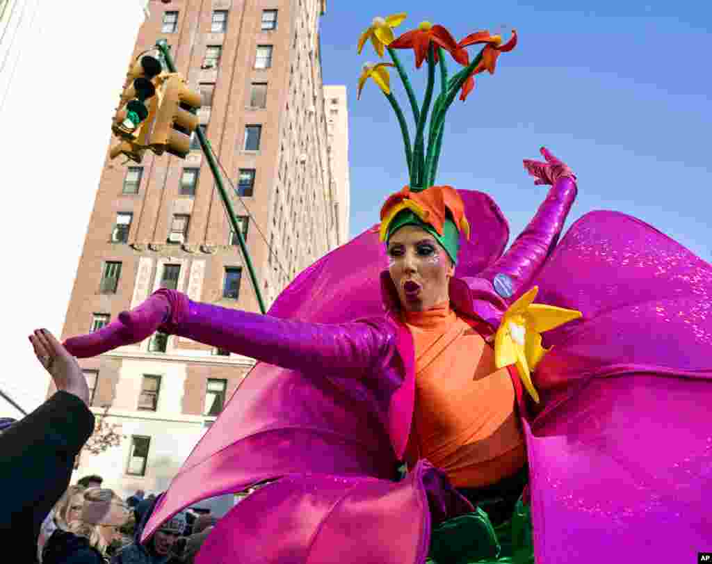 A participant in the Macy's Thanksgiving Day Parade touches hands with a spectator along Central Park West in New York.