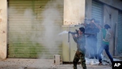 FILE - Libyan military soldiers fire weapons during clashes with Islamic militias in Benghazi, Oct. 29, 2014.