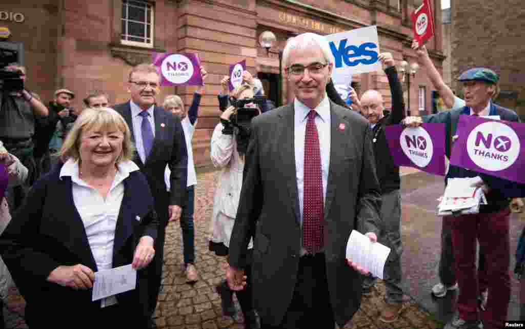 Mantan Kanselir Exchequer dan pemimpin kampanye Better Together, Alistair Darling, bersama istrinya Maggie di luar tempat pemungutan suara di Church Hill Theatre di Edinburgh, Skotlandia (18/9). (Reuters/Stefan Rousseau)