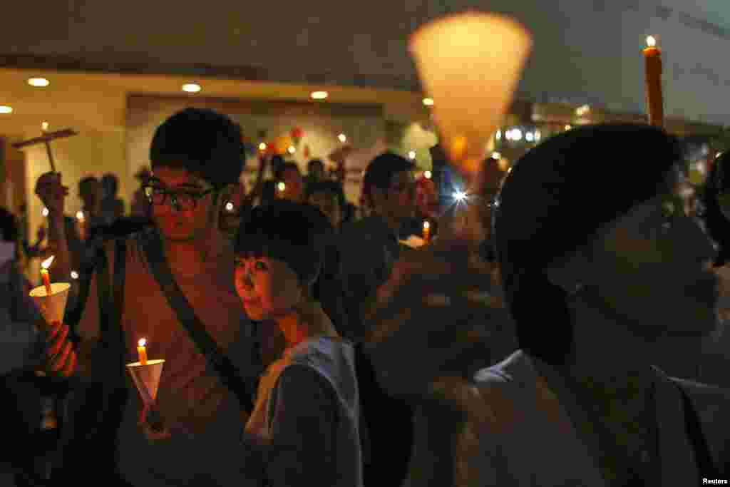 Orang-orang menyalakan lilin dalam kampanye anti kekerasan di pusat kota Bangkok. Menteri Keuangan Thailand menyatakan keprihatinan terhadap dampak buruk pada ekonomi negara itu sebagi akibat dari pertikaian antara para pendukung pemerintah dan pihak oposisi yang tengah mempersiapkan unjuk rasa besar bulan ini yang berisiko terhadap terdorongnya negara yang telah terpecah ini ke ambang kekacauan.