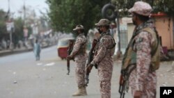 Security personnel stand guard after the government announced to lockdown the city concerns over the spread of the coronavirus, Karachi, Pakistan, March 23, 2020.