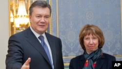 Ukrainian President Viktor Yanukovych, left, greets EU foreign policy chief Catherine Ashton in Kiev, Ukraine, Tuesday, Dec. 10, 2013. 
