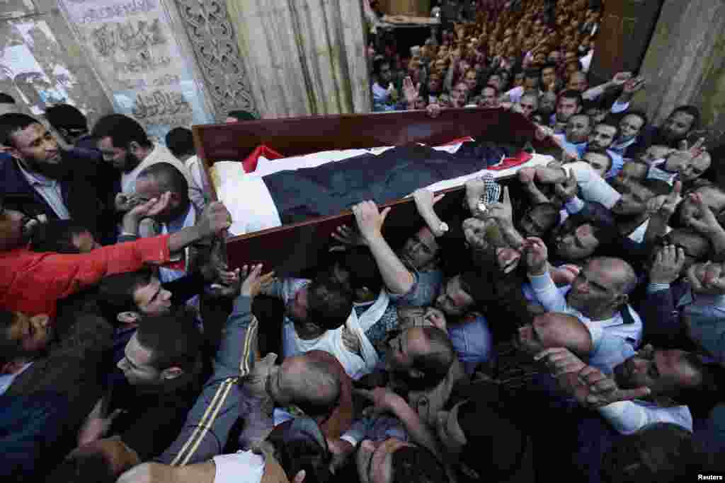 Supporters of the Muslim Brotherhood and Egyptian President Mohamed Morsi carry a body of one of six victims killed during Wednesday's clashes, Al Azhar mosque, Cairo, Egypt, December 7, 2012.