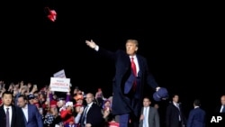 President Donald Trump throws hats to supporters after speaking at a campaign rally at Duluth International Airport, Sept. 30, 2020, in Duluth, Minn.