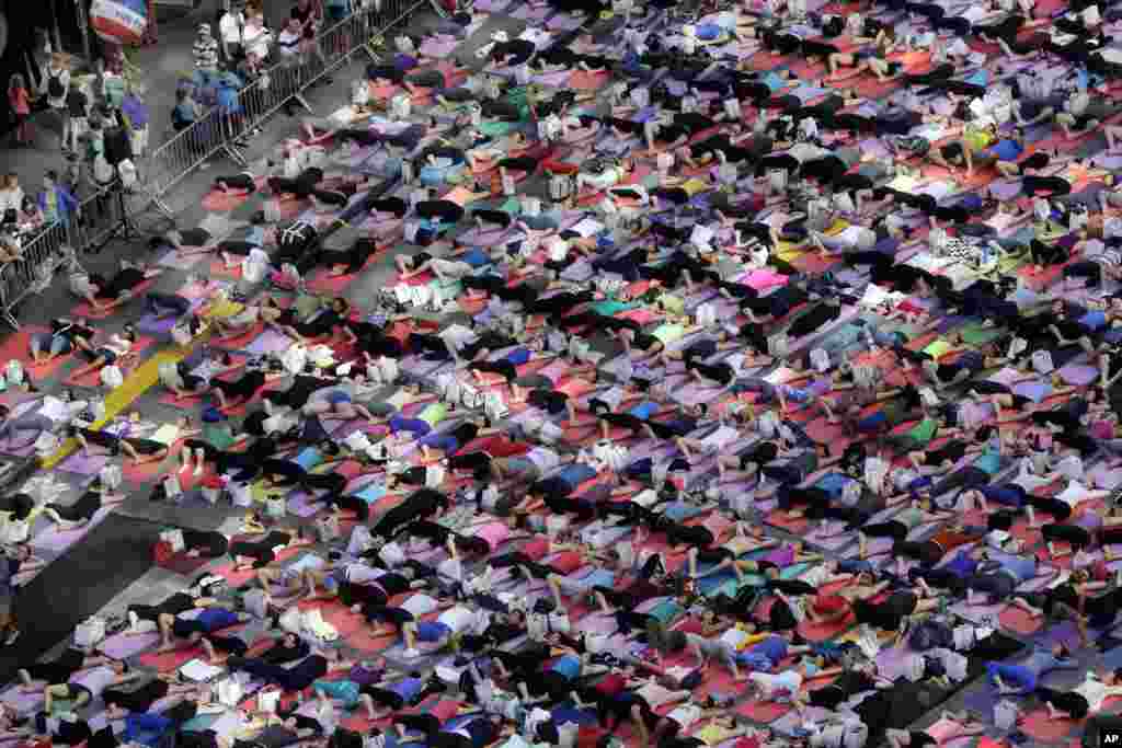 Thousands of New Yorkers are marking the first day of summer by practicing yoga in Times Square, during the 12th annual Solstice in Times Square, sponsored by the Times Square Alliance and Athleta, Gap Inc.'s exercise-wear brand, June 21, 2014.