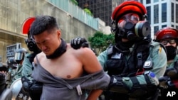 A protester is detained in Central district of Hong Kong on Monday, Nov. 11, 2019. A Hong Kong protester was shot by police Monday in a dramatic scene caught on video as demonstrators blocked train lines and roads during the morning commute.