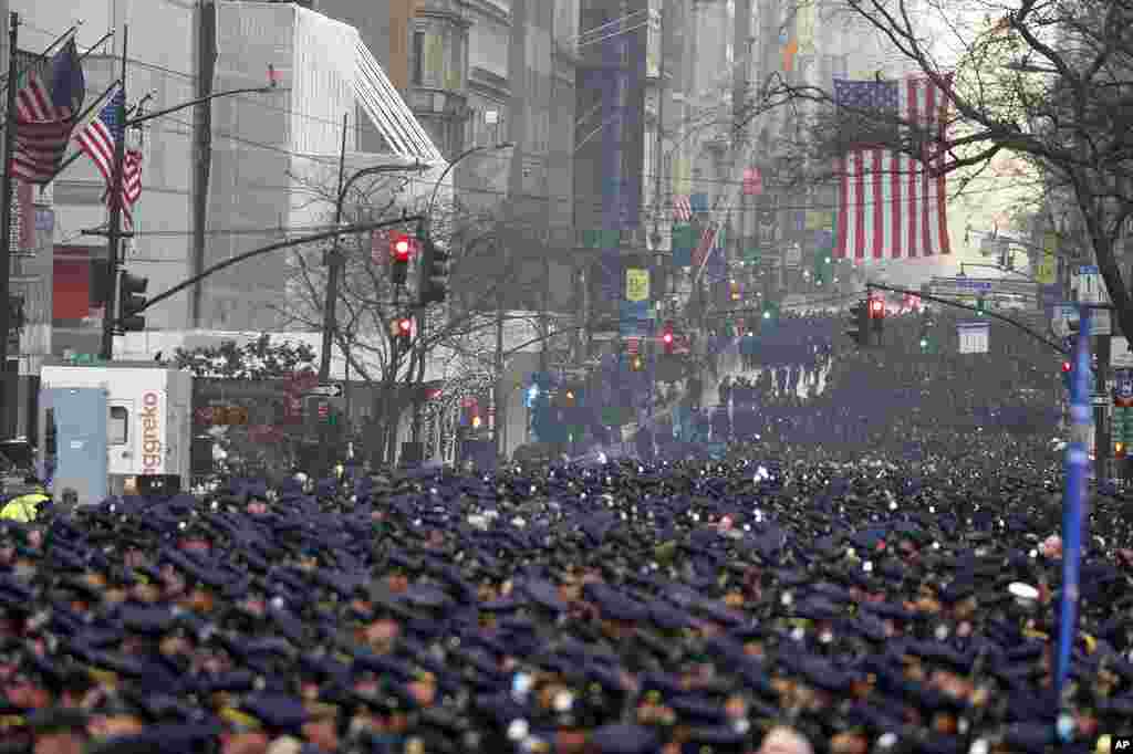 New York Police officers gather along Fifth Avenue for the funeral of Officer Jason Rivera, outside St. Patrick's Cathedral in New York. Rivera and his partner, Officer Wilbert Mora, were fatally wounded when a gunman ambushed them in an apartment last week.