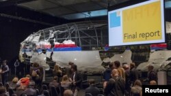 The reconstructed airplane serves as a backdrop during the presentation of the final report into the July 2014 crash of Malaysia Airlines flight MH17, in Gilze Rijen, the Netherlands, October 13, 2015.