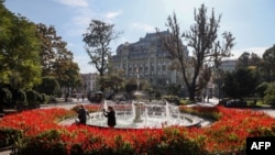 FILE - People take pictures at the fountain of the City Garden in the Ukrainian city of Odesa on Oct. 12, 2022. 