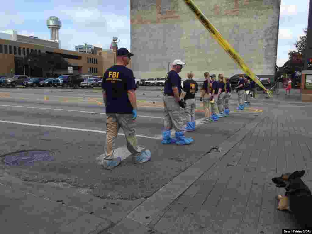 Law enforcement personnel investigate a mass shooting scene after an attack that killed and wounded Dallas police officers, in Dallas, Texas, July 8, 2016.