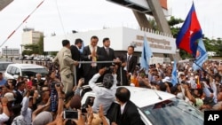 Sam Rainsy, pemimpin partai oposisi Kamboja CNRP, menyambut para pendukung saat tiba di bandar udara internasional Phnom Penh (19/7). (AP/Heng Sinith)