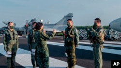 Presiden Taiwan Tsai Ing-wen (tengah) berbicara dengan personel militer di dekat pesawat tang terparkir di lintasan di Jiadong, Taiwan, pada 15 September 2021. (Foto: Taiwan Presidential Office via AP, File)