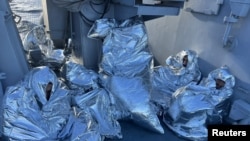 Grupa migranata umotanih u pokrivače za spasavanje, nakon što su spaseni iz voda oko ostrva Evija, Grčka, 1. novembra 2022.