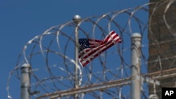 Un drapeau américain flotte derrière les barbelés à la base navale de Guantanamo Bay, à Cuba, le 17 avril 2019. 