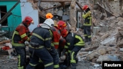 Rescuers carry the body of a woman found under debris of a residential house destroyed by a Russian missile attack in Mykolaiv, Ukraine Nov. 1, 2022.