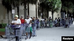 Shoppers wait in a long line for a Sam's Club store to open before sunrise, as people rushed to buy supplies ahead of the arrival of Hurricane Dorian in Kissimmee, Florida, Aug. 30, 2019. 
