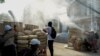 Protesters stand behind a barricade at Sanchaung district in Yangon, Myanmar, March 8, 2021. 