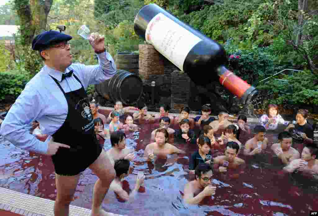Bourgogne wine maker Laboure-Roi vice president Thibault Garin (L) toasts the company's 2013 Beaujolais Nouveau wine with guests in the wine spa at the Hakone Yunessun spa resort facilities in Hakone town, Kanagawa prefecture, some 100-kilometers west of Tokyo, Japan.