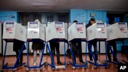 FILE - Voters fill out their forms as they prepare to vote at a polling station in the Brooklyn borough of New York City, Nov. 8, 2016. Races in Kentucky and New York that could unseat veteran Washington lawmakers in November are being closely watched.