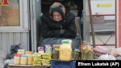 An elderly Ukrainian woman sells home made products in downtown Kiev, Ukraine, on Wednesday, Feb. 3, 2016.