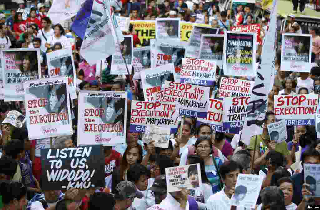 Aktivis memegang poster ketika melakukan pawai ke Kedutaan Besar Indonesia, memegang lilin bagi terpidana mati Mary Jane Veloso di Makati, Filipina, 28 April 2015.