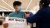 Lucas Kittikamron-Mora (13), memegang tanda untuk mendukung vaksinasi COVID-19 saat disuntik vaksin Pfizer pertamanya di Departemen Kesehatan Masyarakat Cook County, di Des Plaines, Illinois, 13 Mei 2021. 