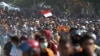 Seorang peserta unjuk rasa mengibarkan bendera saat berpawai ke gedung DPRD Sulawesi Tenggara di Kendari, Sulawesi Tenggara, 26 September 2019. (Foto: Antara via Reuters)