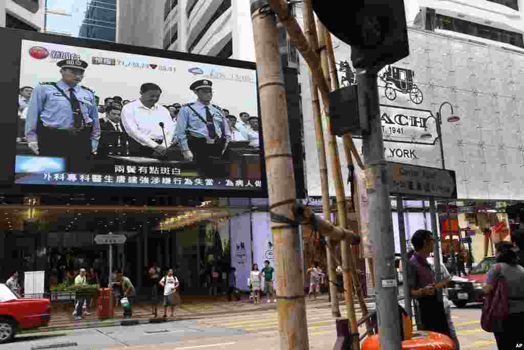 A TV screen shows a news report of disgraced politician Bo Xilai standing in the courtroom, flanked by police guards at Jinan Intermediate People's Court in eastern China's Shandong province, in Hong Kong, August 22, 2013.