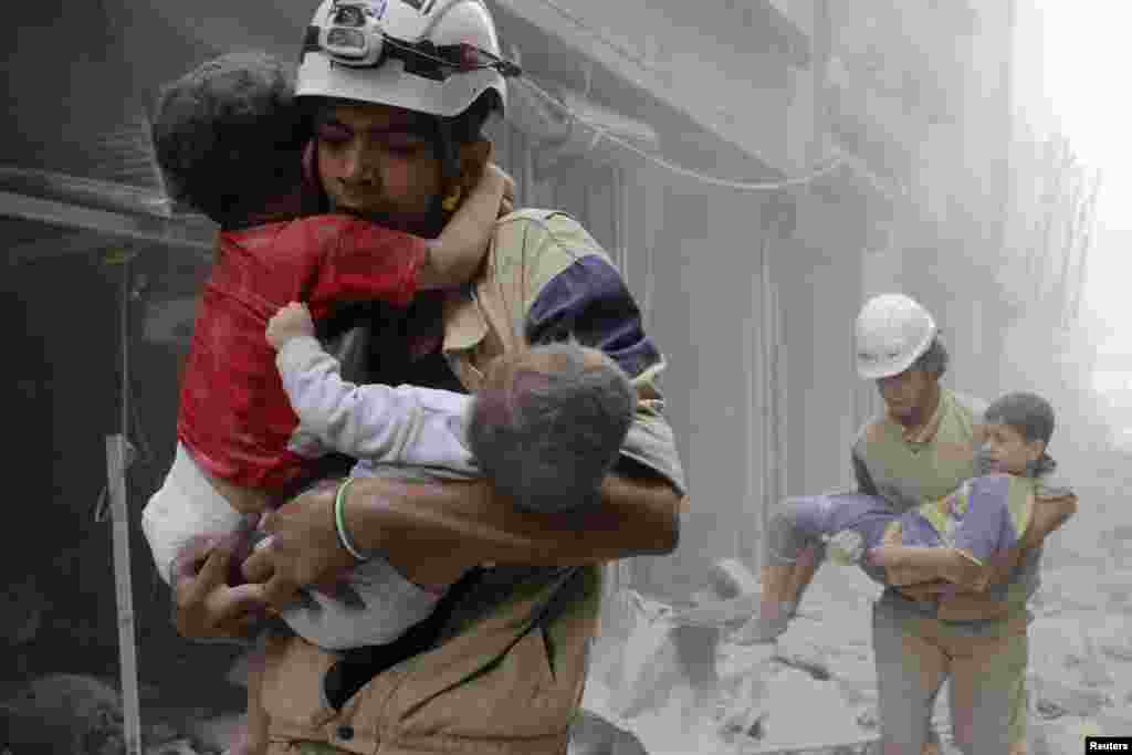 Members of the Civil Defence rescue children after what activists said was an air strike by forces loyal to Syria's President Bashar al-Assad in al-Shaar neighborhood of Aleppo.