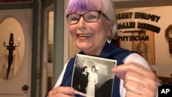 Nurse practitioner Sigrid Stokes, 76, holds a photograph of her mother talking to Shirley Temple, at the Salinas Valley Memorial Hospital in Salinas, Calif., Wednesday, Feb. 3, 2021. (AP Photo/Haven Daley)