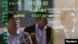 Bayangan warga Tokyo terlihat pada papan elektronik indeks saham Jepang, Nikkei, Senin (17/11). Resesi di Jepang menyebabkan bursa saham turun di Tokyo dan beberapa bursa utama lainnya.